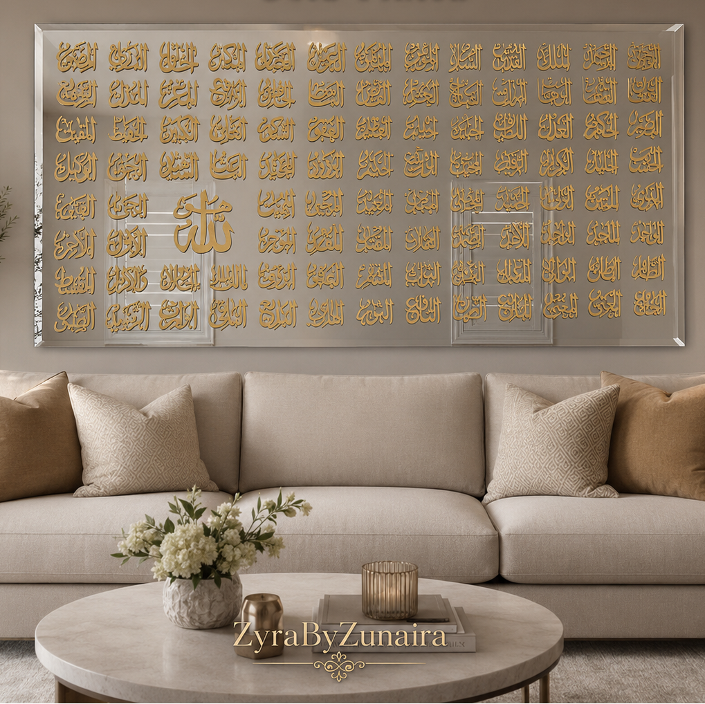 A large rectangular gold-framed mirror with intricate gold Arabic calligraphy designs across the glass, displayed in a modern living room setting above a beige sofa. Text overlays at the top read '99 Names of Allah Mirror Gold Finish' and a watermark at the bottom reads 'YraByZunaira'.