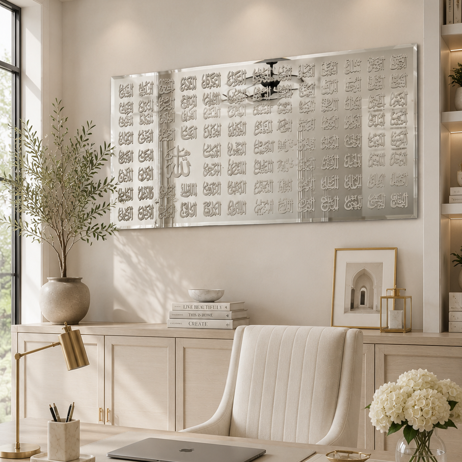 A bright, modern home office featuring a large light wood desk, a white tufted office chair, a brass desk lamp, and a large multi-panel silver wall art piece mounted on the wall above the desk.