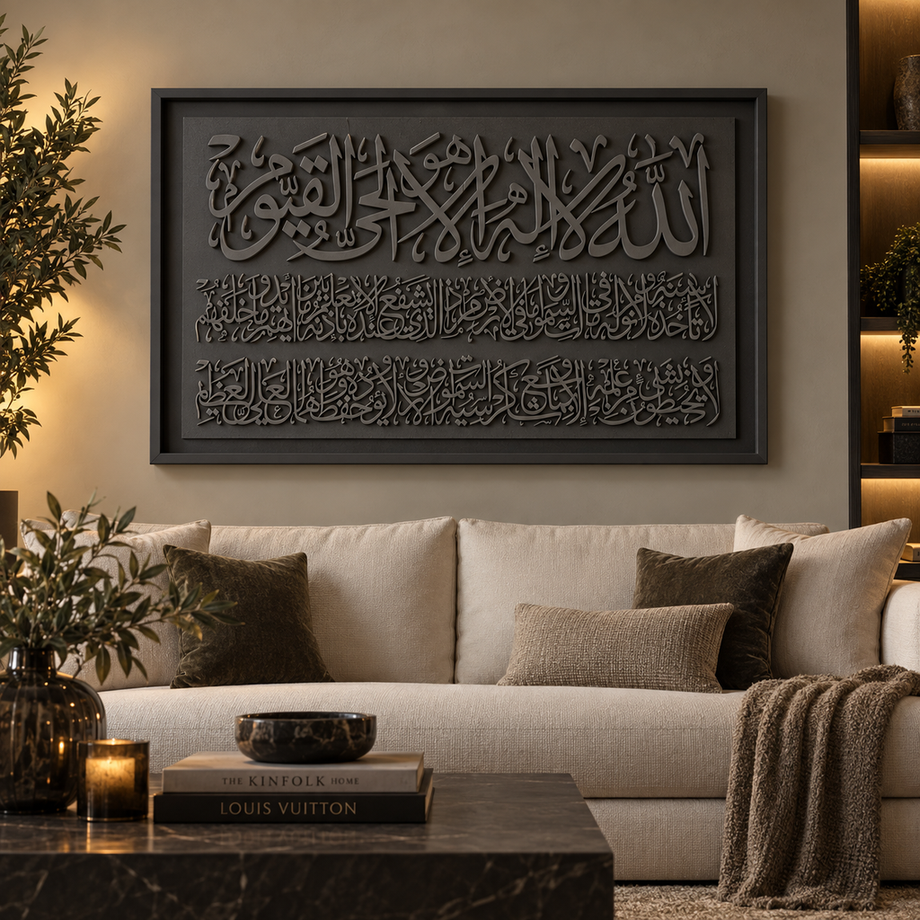 Large framed Islamic wall art featuring embossed Arabic calligraphy in dark charcoal gray, displayed above a beige sofa in a modern living room setting.