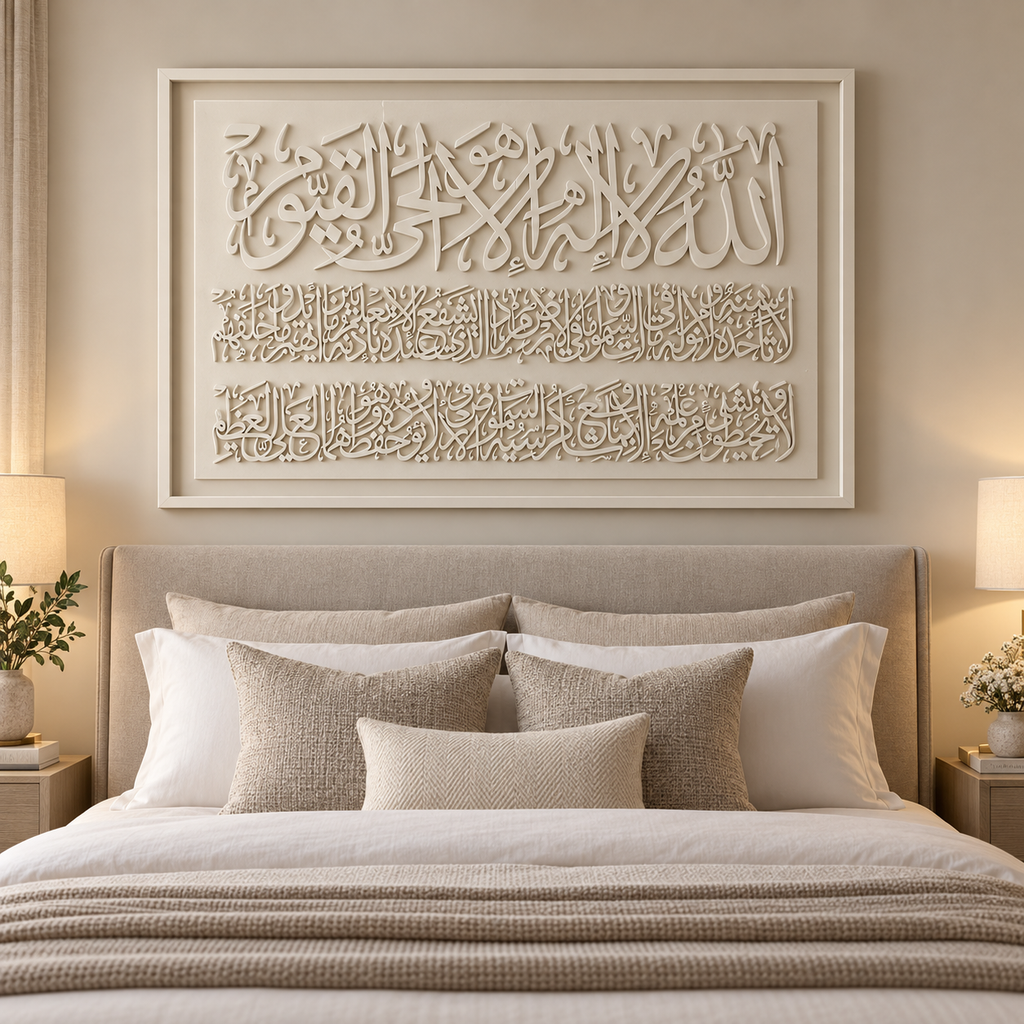 A large rectangular framed Islamic wall art piece with intricate Arabic calligraphy, displayed above a neatly made bed in a warm, modern bedroom setting.