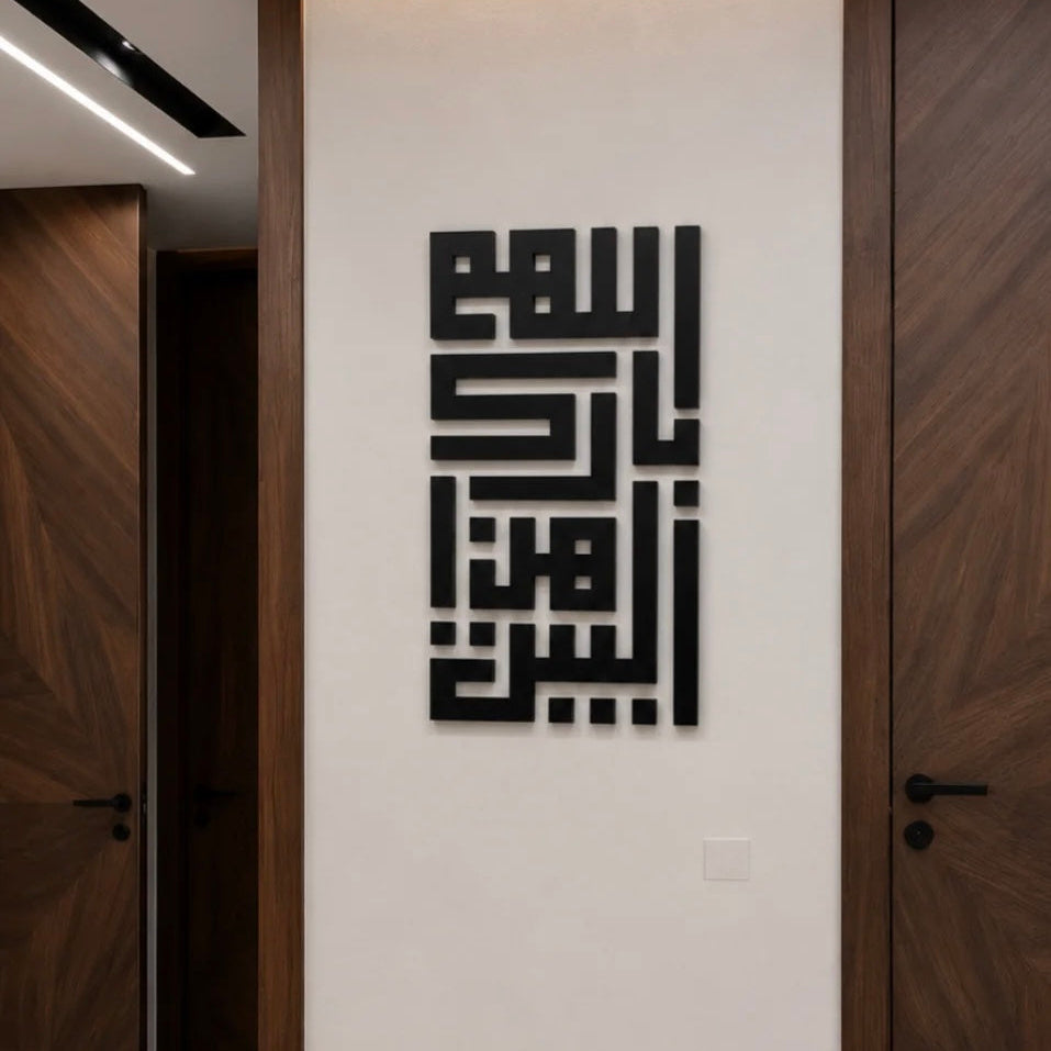 Black Arabic calligraphy wall art mounted on a white wall in a modern hallway with dark wood doors.
