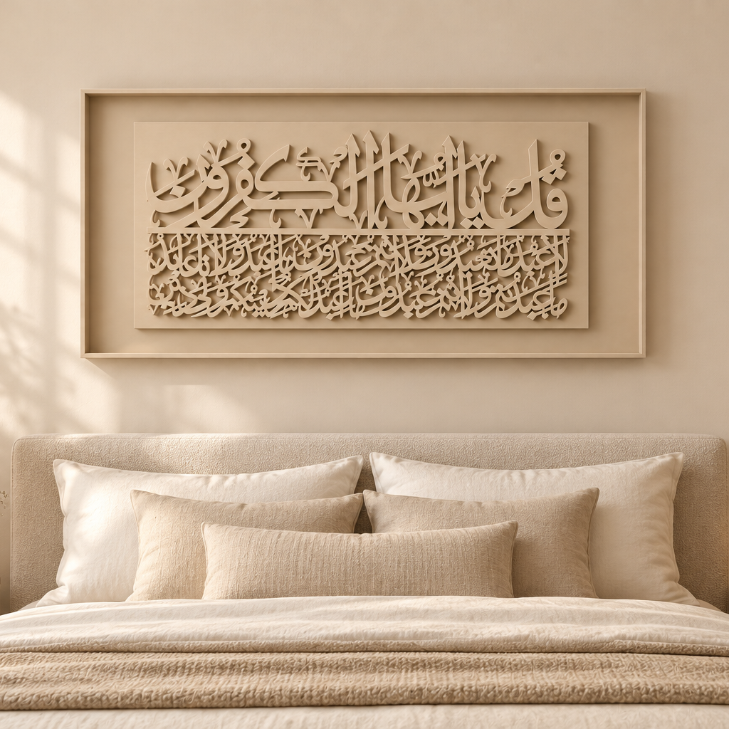 A beige framed Islamic wall art piece with intricate Arabic calligraphy, displayed above a neatly made bed in a warm, modern bedroom setting.