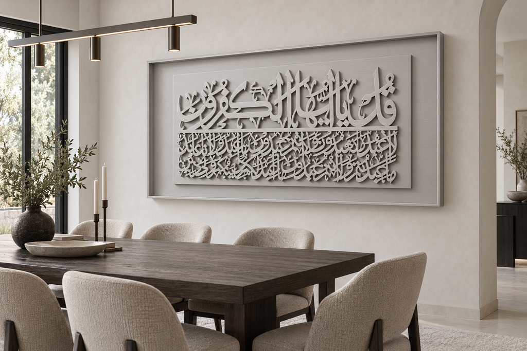 Large rectangular framed Islamic calligraphy wall art hanging above a dark wood dining table with upholstered chairs in a modern neutral-toned dining room.