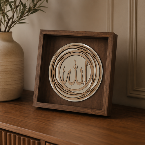 A square wooden shadow box display featuring layered circular wood cutouts with Arabic calligraphy, placed on a wooden cabinet next to a beige ceramic vase with green branches.